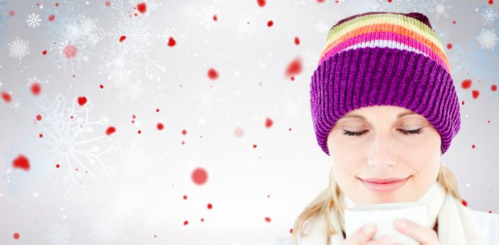 Delighted woman with a colorful hat and a cup in her hands against snowflake pattern