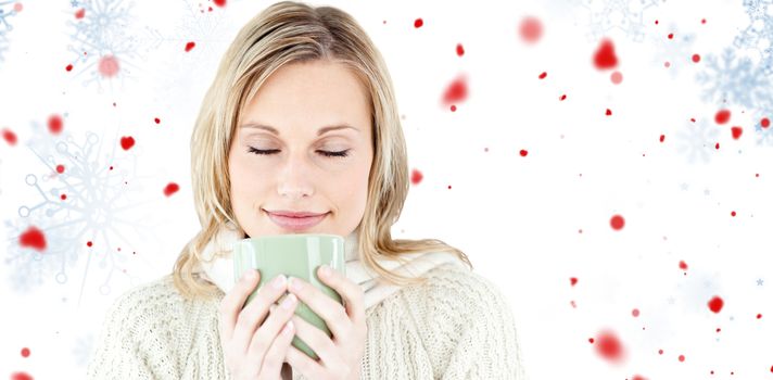 Happy woman enjoying a hot coffee standing  against snowflake pattern