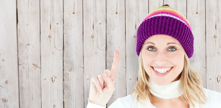 Positive woman showing up smiling at the camera against white background against wooden background