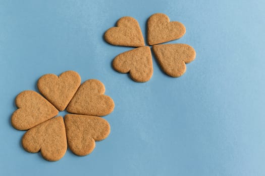 Breakfast. Close-up of heart shaped cookies like a flower petals.. Blue background. Copy space