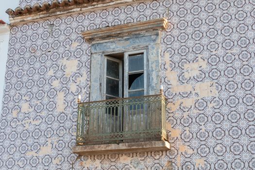 broken window of a typical ruined house with its tiled facade in Portugal