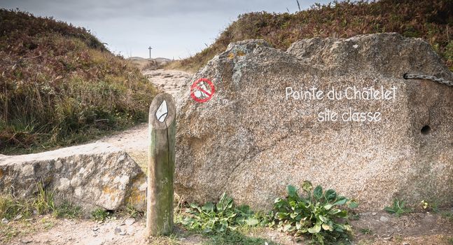 Pointe du Châtelet Classified Site written in paint on a stone at the entrance of a path on the island of Yeu, France