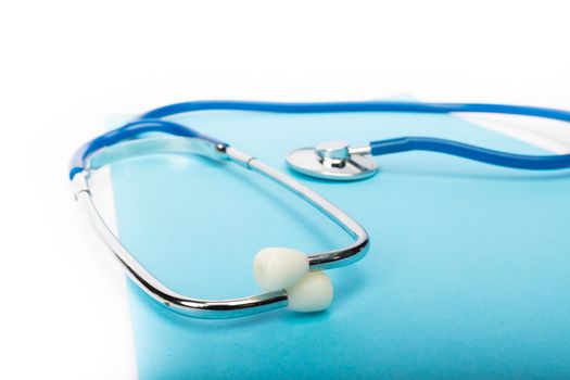 medical record and blue stethoscope close-up on white background in studio