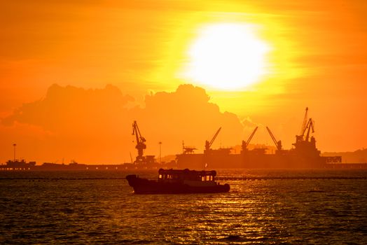 commercial dock with ship and cranes in sunset