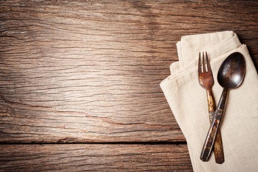 dinning table background with old brass spoon and fork