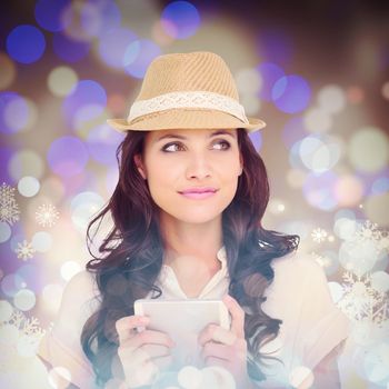 Pretty brunette holding her phone against snowflake pattern