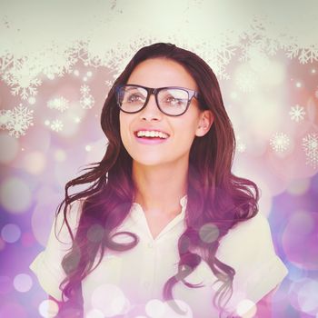 Pretty brunette in hipster glasses against snowflake pattern