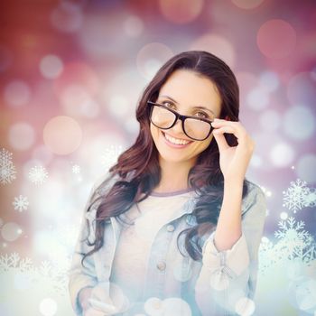 Brunette with smartphone against snowflake pattern