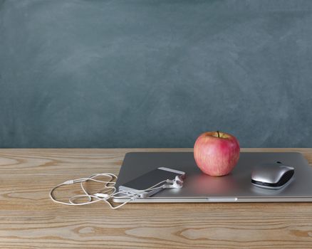 Back to school concept with basic modern technology on desktop with chalkboard in background  