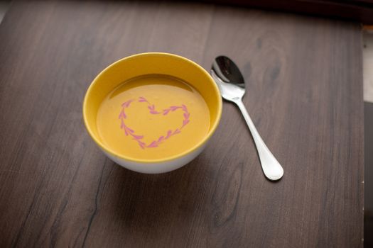 Vegetarian autumn - Pumpkin cream soup with hearth decoration on wooden table