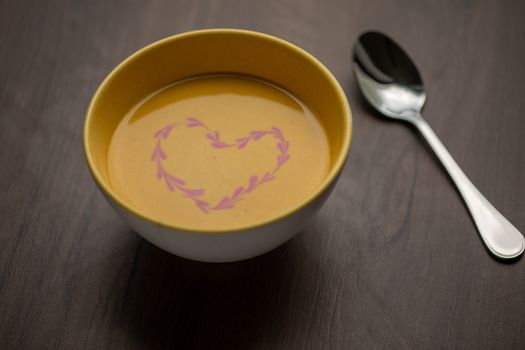 Vegetarian autumn - Pumpkin cream soup with hearth decoration on wooden table