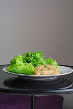 Chicken breast steak with spices serve with fresh green lettuce on white plate. High protein food. Healthy for loose weight.