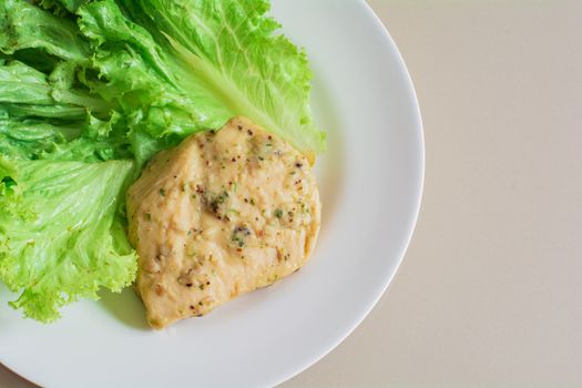 Chicken breast steak with spices serve with fresh green lettuce on white plate. High protein food. Healthy for loose weight.