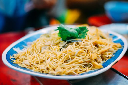 Delicious Chinese food. Stir fried noodle with shiitake on plate serve in restaurant at china town in Thailand. Selective focusing.