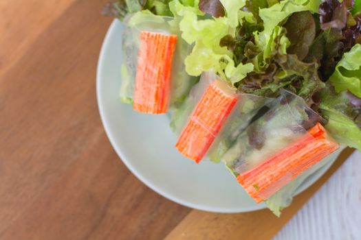 Crab stick in salad roll on white dish. Healthy food concept.