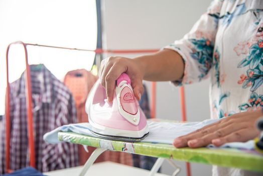 Close up of woman ironing clothes on ironing board