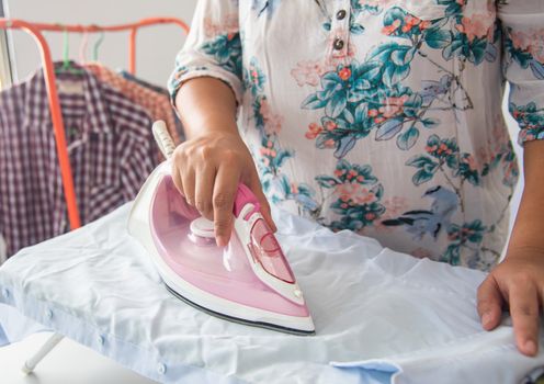 Close up of woman ironing clothes on ironing board