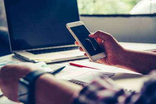 bussinessman are using their mobile to work with a laptop
