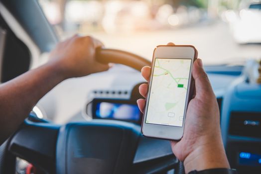  driver sitting in the car and holding  mobile smart phone with map gps navigation application