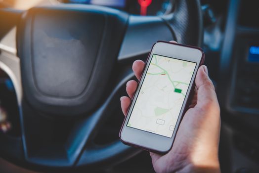  driver sitting in the car and holding  mobile smart phone with map gps navigation application