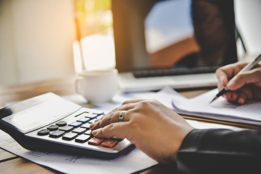 Businessman are working with a calculator and document. Meeting report in progress. in office business concept