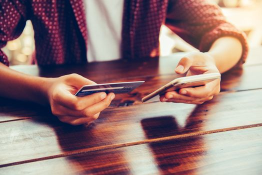 Woman holding credit cards and mobile phones are now shopping over the internet by paying by credit card.