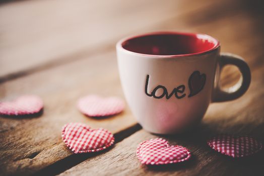 Glass with the words "Love" placed on the wooden floor