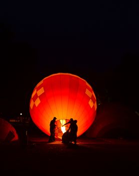 The team is preparing a balloon with a fire to make the balloon rise.