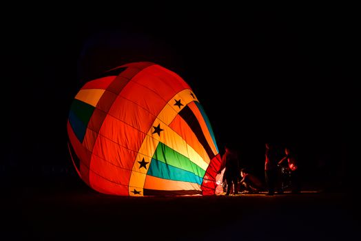 The team is preparing a balloon with a fire to make the balloon rise.