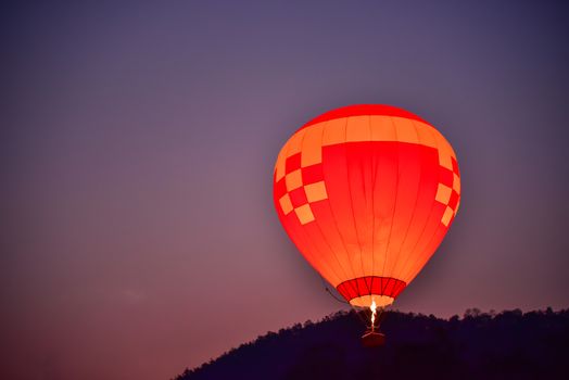 The balloon is floating in the sky in the early morning.