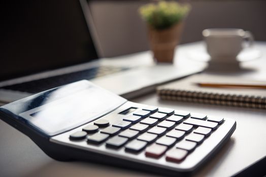 calculator is placed on the desk in the evening office.