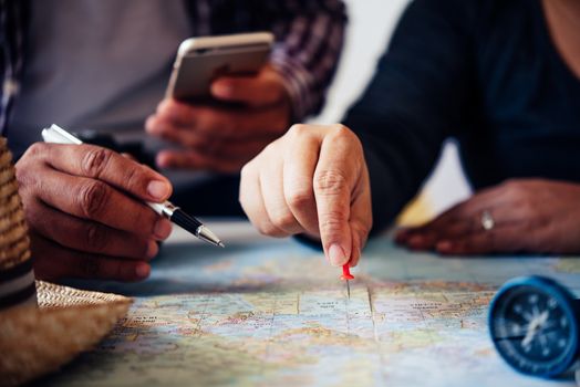 Travelers are planning a trip by searching the route on the map and searching for information on the internet.