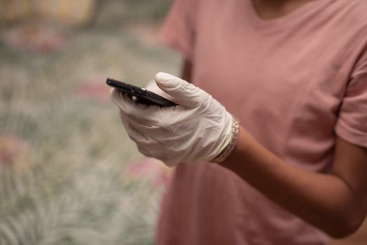 Young boy on his phone with latex gloves on