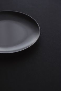 Empty plates on black background, premium dishware for holiday dinner, minimalistic design and diet concept