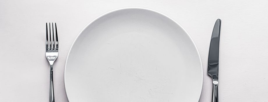 Empty plate and cutlery as mockup set on white background, top tableware for chef table decor and menu branding design