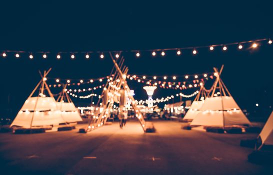 Blurred images of the background party in the festive festivities during the night, consisting of people and glittering bokeh.