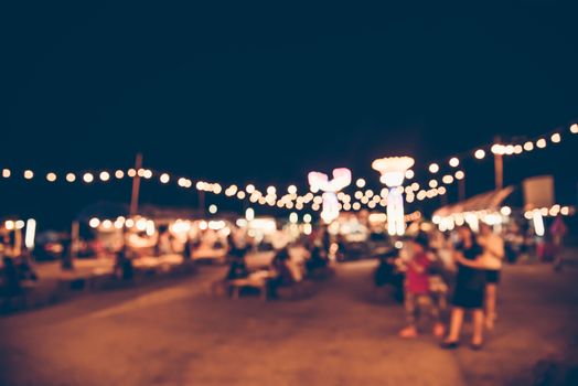 Blurred images of the background party in the festive festivities during the night, consisting of people and glittering bokeh.