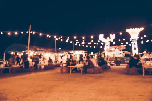 Blurred images of the background party in the festive festivities during the night, consisting of people and glittering bokeh.