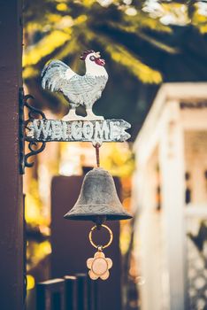 vintage wooden sign "Welcome" with a bell under the sign on door of cafe