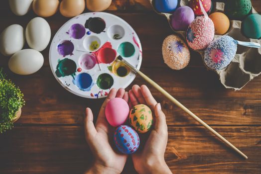 young girl painting Easter eggs for eastertime at home