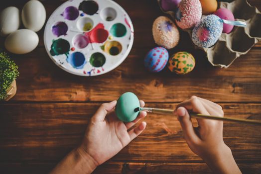 young girl painting Easter eggs for eastertime at home