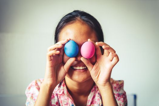 young girl painting Easter eggs for eastertime at home