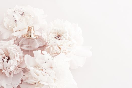 Fragrance bottle as luxury perfume product on background of peony flowers, parfum ad and beauty branding design