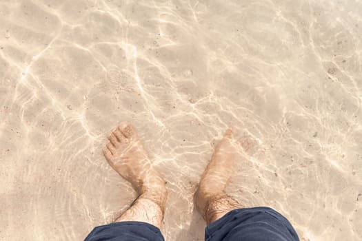 barefoot in clear water on the beach