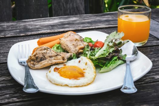 grilled chicken fried egg sausage and salad with juice