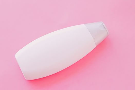 Blank label shampoo bottle or shower gel on pink background, beauty product and body care cosmetics, flatlay