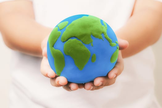 kid holding the clay globe in hand