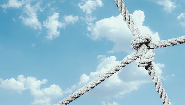 rope knot of net against blue sky background. unity and collaboration concept