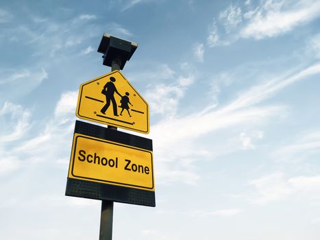 school zone sign against sky background