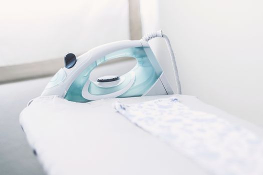steam iron with dress on ironing board